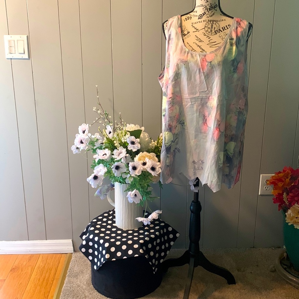 Sleeveless blouse. Beautiful Pastel flowers on a shaded pale blue background.